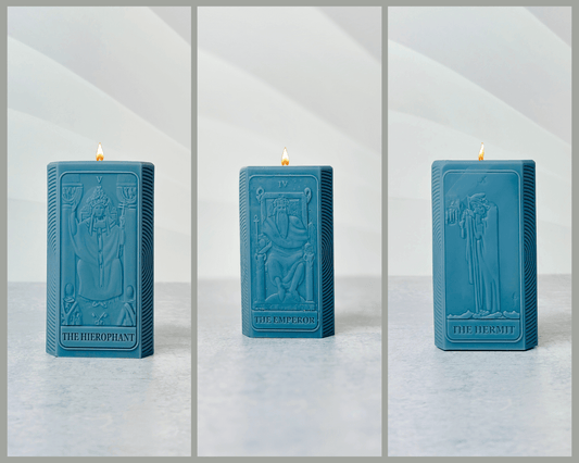 Three blue spiritual candles featuring The Hierophant, The Emperor, and The Hermit designs.