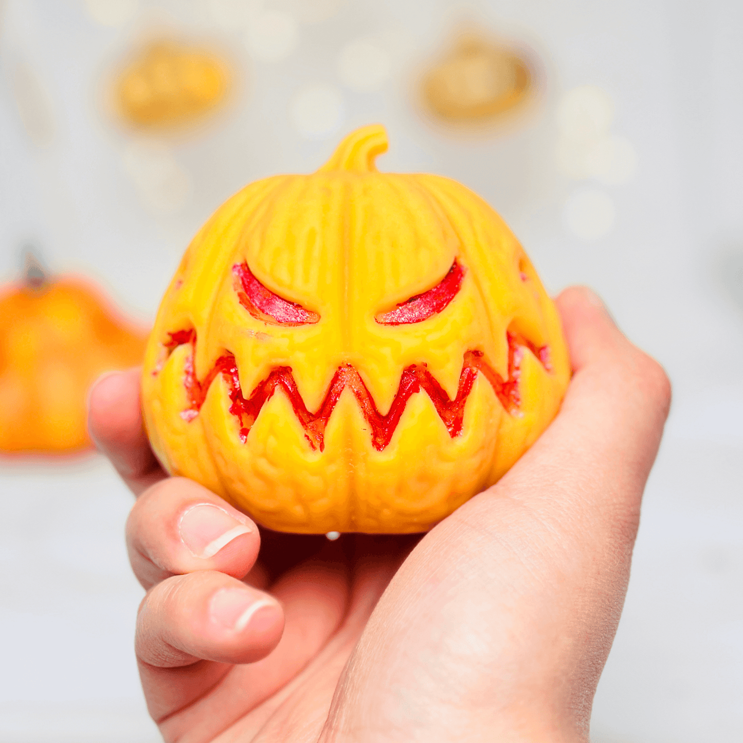 Hand holding a spooky Jack-O-Lantern candle made with silicone mold for Halloween decor.