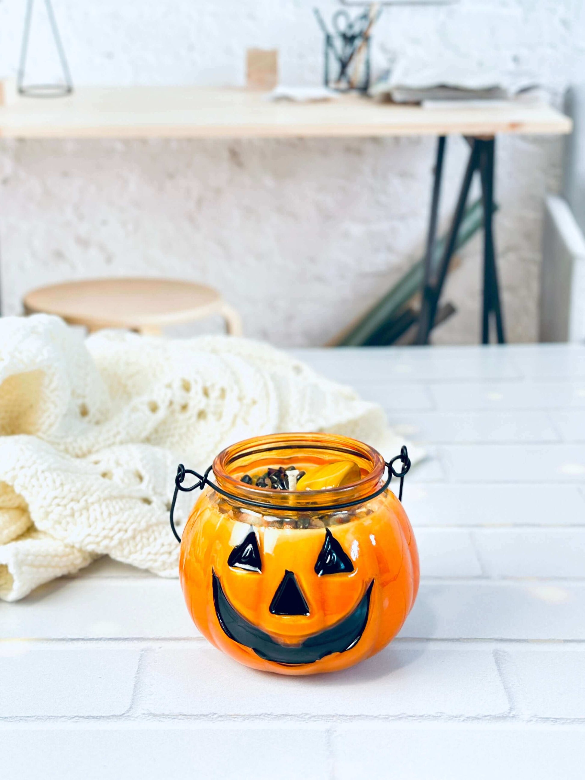 Jack O Lantern soy candle jar with a smiling face, perfect for Halloween decor and cozy ambiance.