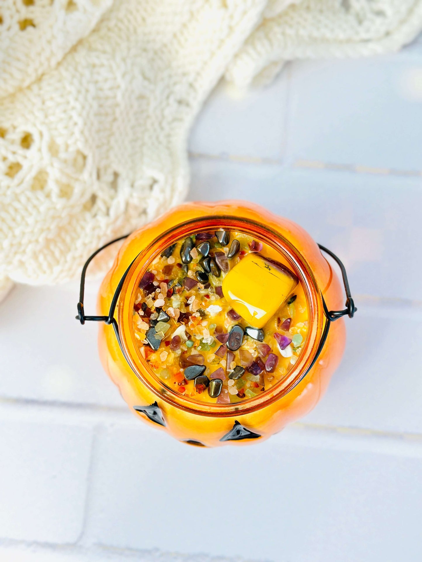 Top view of Jack O Lantern glass pumpkin candle filled with colorful crystals and soy wax, perfect for fall ambiance.