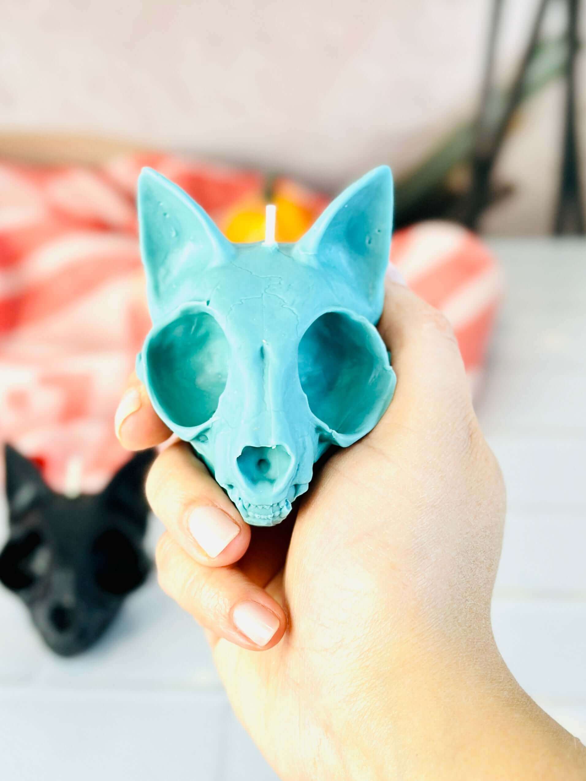 Hand holding a blue cat skull candle made with a silicone mold, showcasing its unique design for Halloween.