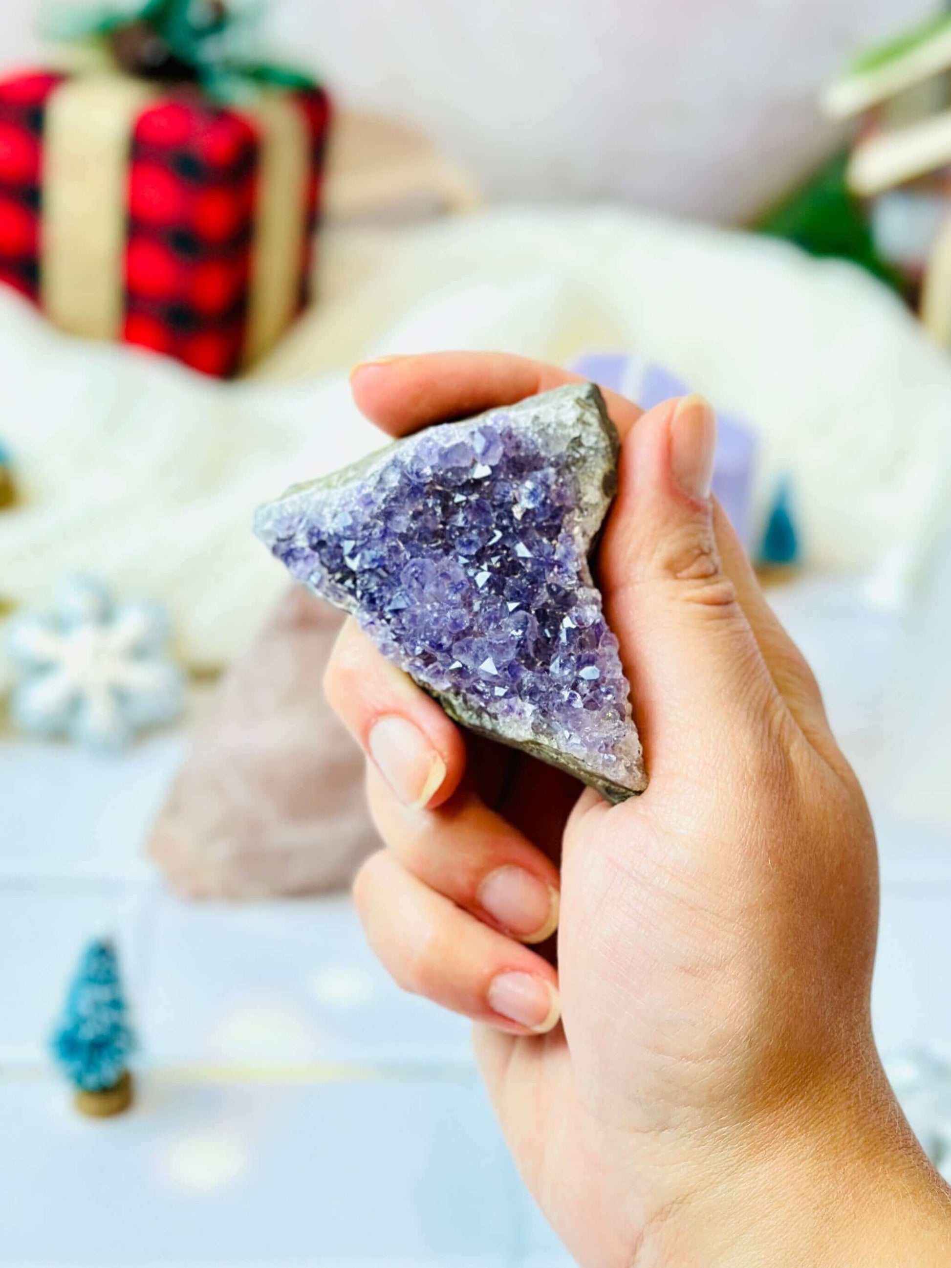 Hand holding a beautiful purple amethyst crystal, perfect for adding a touch of elegance to home decor.