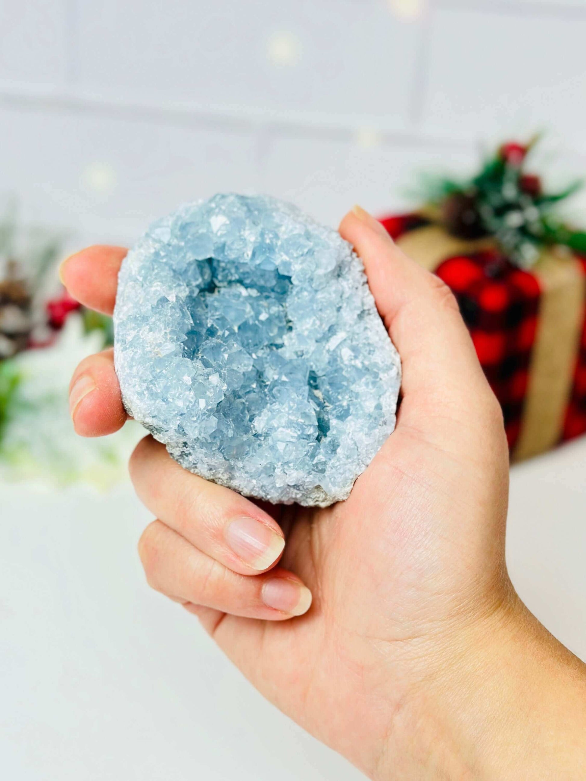 Unique blue celestite crystal geode held in hand, showcasing its sparkling interior and calming hues.