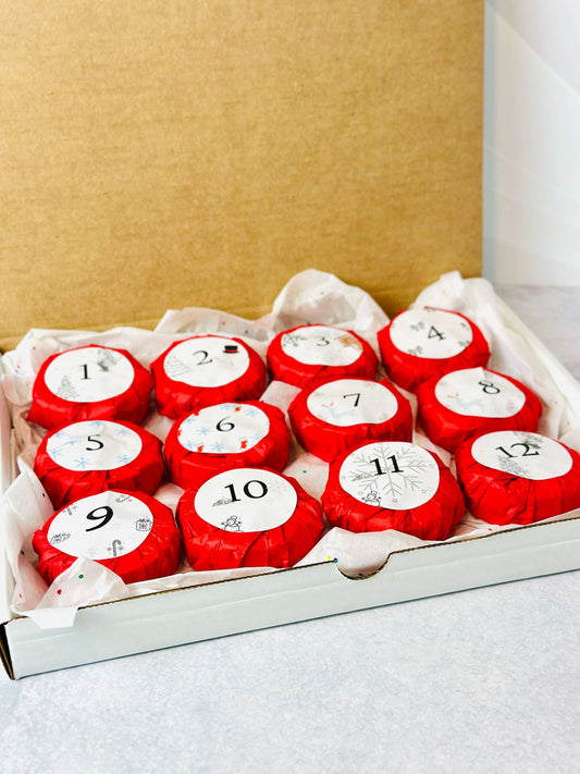 Bookish Candles Advent Calendar 2025 featuring 12 red-wrapped candles in a gift box for Christmas.